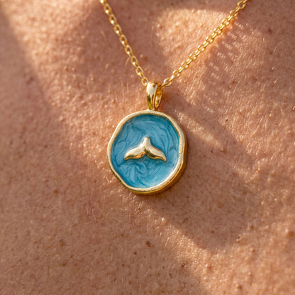collar cola de ballena dorado y azul sobre piel