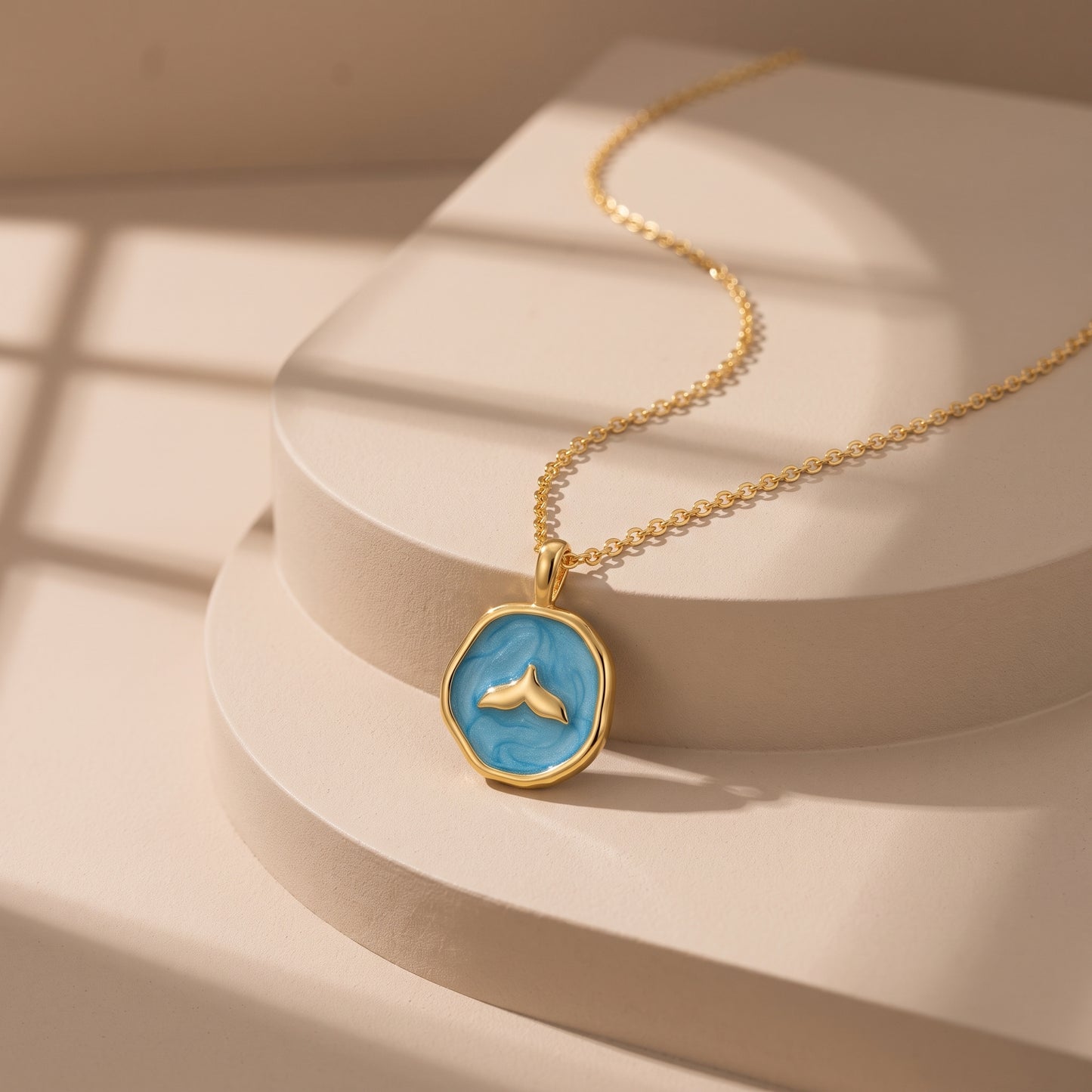 collar cola de ballena dorado y azul sobre plataforma elegante
