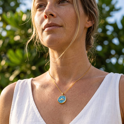 Modelo rubia elegante con collar cola de ballena dorado y azul 2