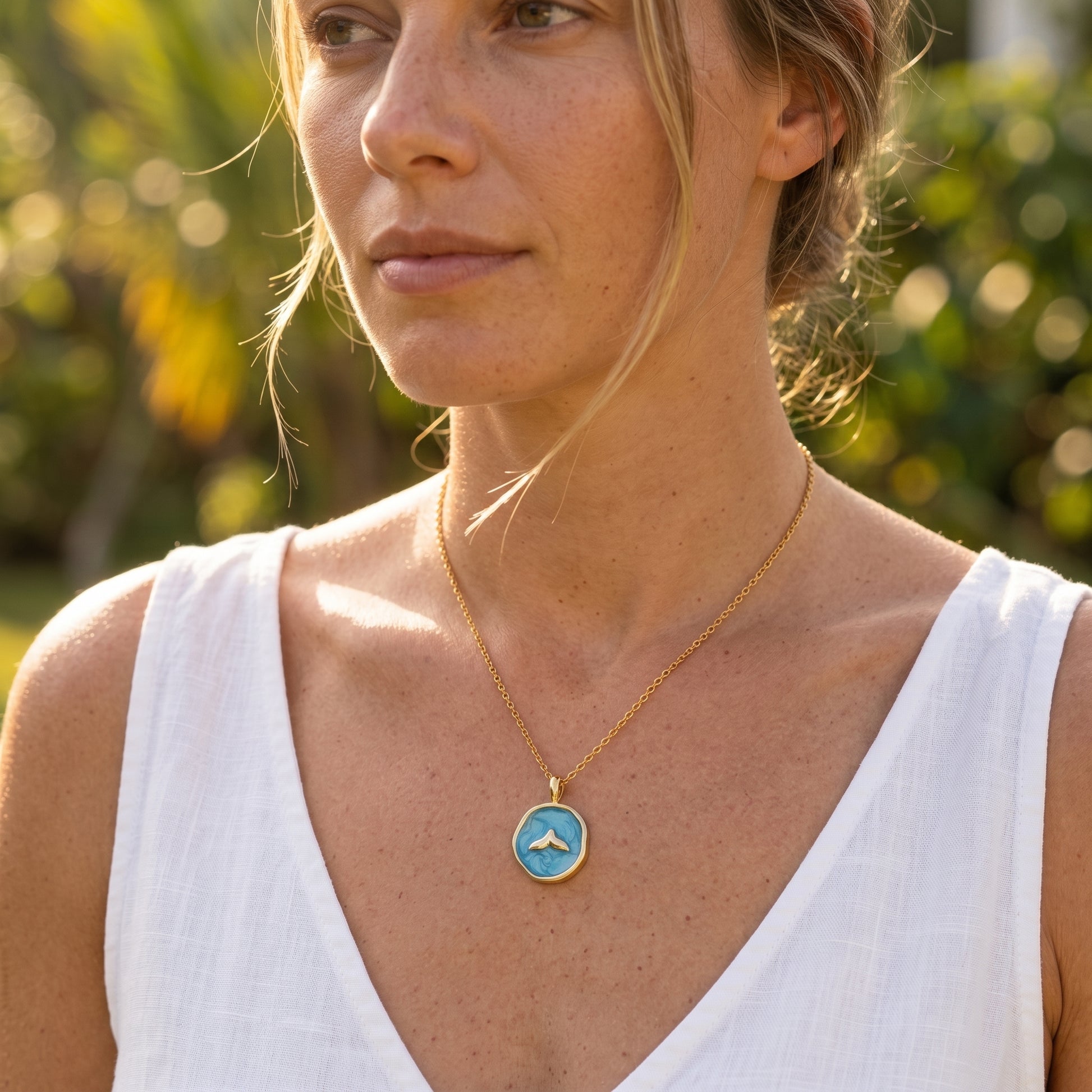 Modelo rubia elegante con collar cola de ballena dorado y azul